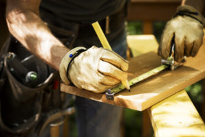 Carpenter Measuring A Wooden Plank.